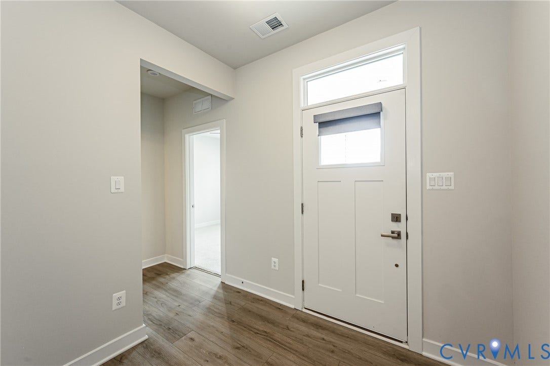 7683 Autumn Leaves Lane, Estates The Groves At New Kent, New Kent, VA 23124 Entryway featuring a white paneled door with a transom window, wood-finish flooring, light gray wall paint, and white trim