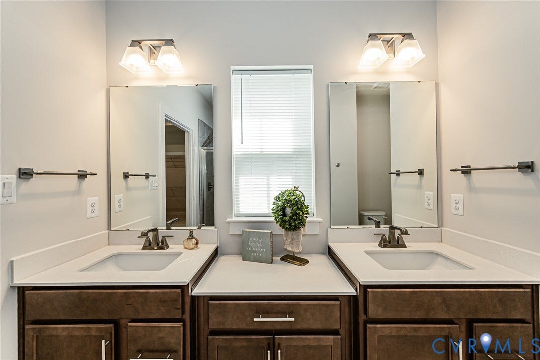 7683 Autumn Leaves Lane, Estates The Groves At New Kent, New Kent, VA 23124 Dual vanity with integrated sinks, light-toned countertops, and rich wood-finish cabinetry