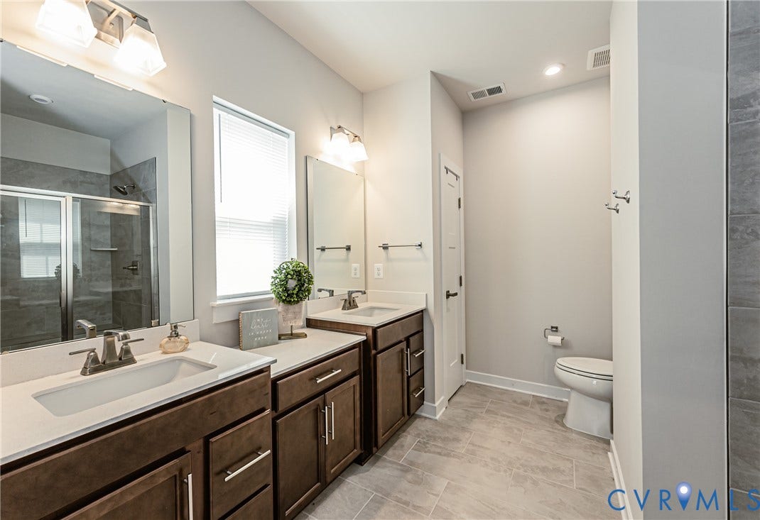 7683 Autumn Leaves Lane, Estates The Groves At New Kent, New Kent, VA 23124 Dual vanity with rich wood-finish cabinetry, white countertops, and modern chrome fixtures