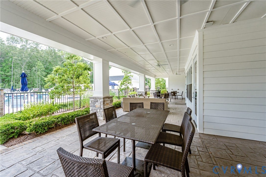 7683 Autumn Leaves Lane, Estates The Groves At New Kent, New Kent, VA 23124 Covered outdoor patio with a coffered ceiling, stone-clad pillars, and stamped concrete flooring