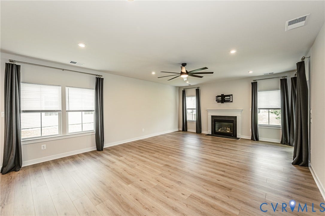 7683 Autumn Leaves Lane, Estates The Groves At New Kent, New Kent, VA 23124 Expansive room featuring wood-finish flooring, a contemporary fireplace with a white mantel, recessed lighting, and a ceiling fan
