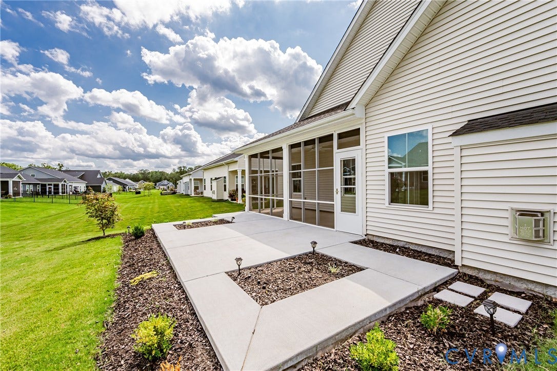 7683 Autumn Leaves Lane, Estates The Groves At New Kent, New Kent, VA 23124 Expansive concrete patio with decorative landscaping, screened enclosure, and siding exterior
