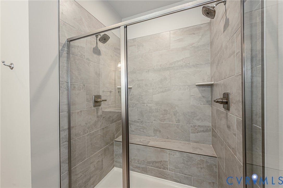 7683 Autumn Leaves Lane, Estates The Groves At New Kent, New Kent, VA 23124 Enclosed shower with full-height tile surround, dual showerheads, built-in bench, and integrated shelving