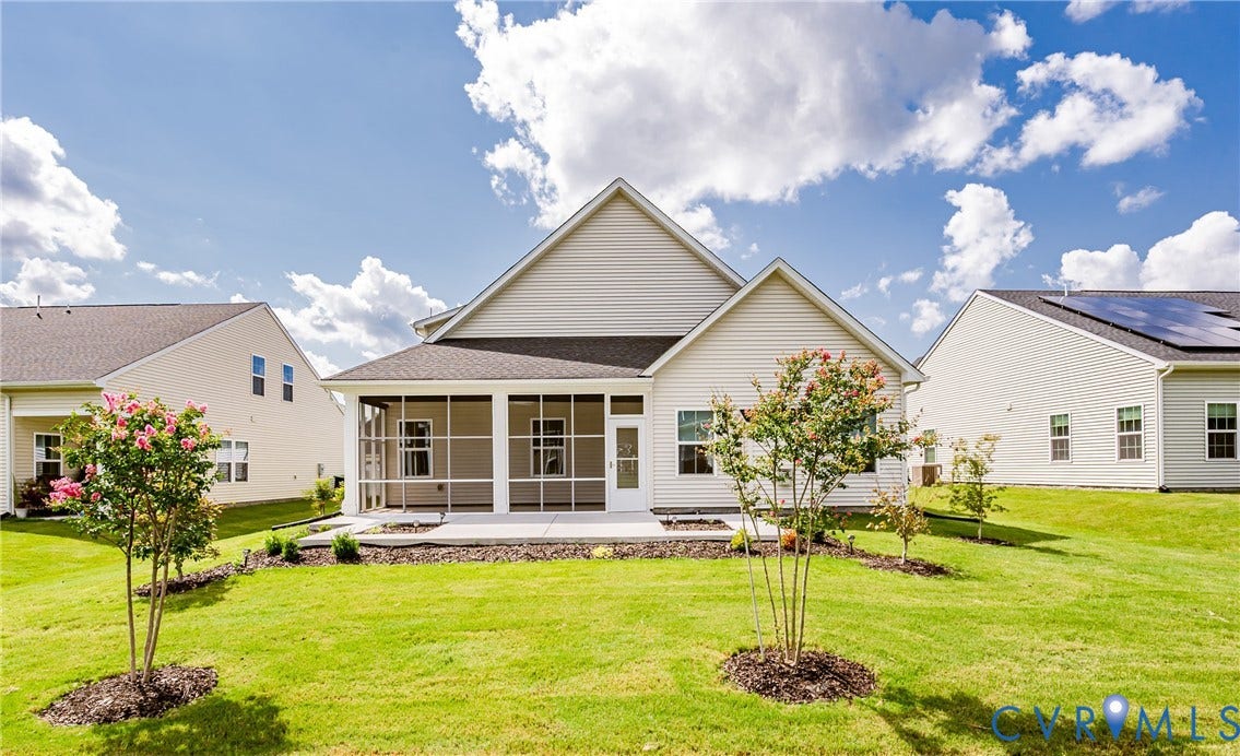 7683 Autumn Leaves Lane, Estates The Groves At New Kent, New Kent, VA 23124 Rear exterior featuring a screened porch, concrete patio, and a manicured lawn with planted trees