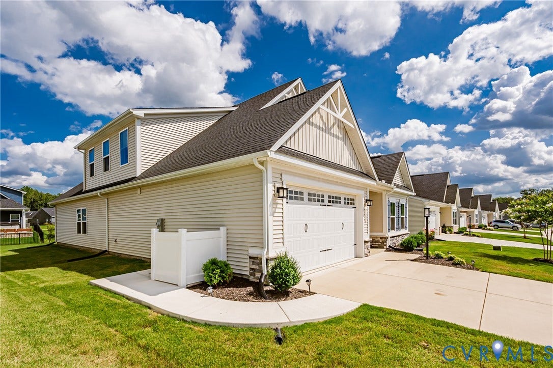 7683 Autumn Leaves Lane, Estates The Groves At New Kent, New Kent, VA 23124 Contemporary architecture with gabled roof lines, white siding, a two-car garage, and established landscaping