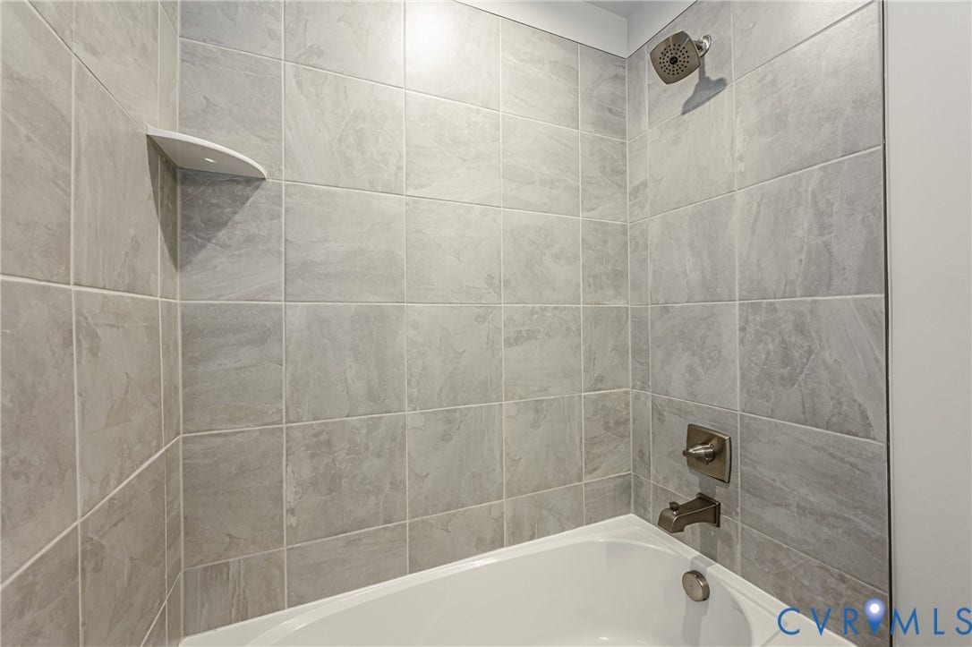 7683 Autumn Leaves Lane, Estates The Groves At New Kent, New Kent, VA 23124 Bathtub with gray tile surround, corner shelf, and bronze-finish fixtures