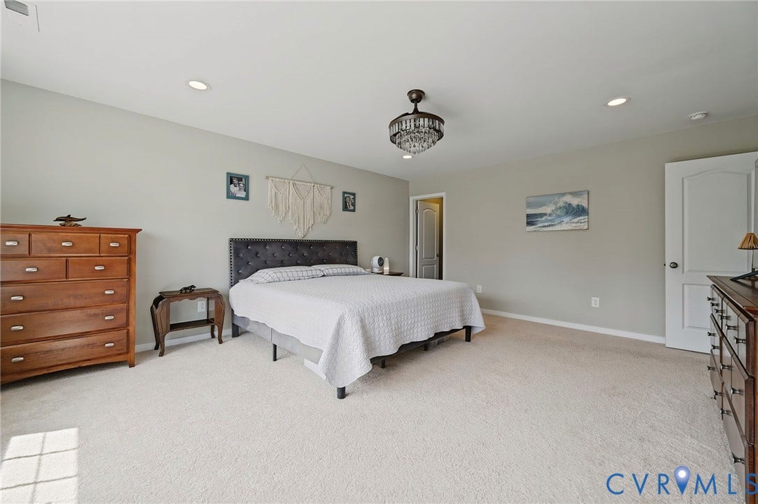 Spacious room featuring neutral wall tones, recessed lighting, a chandelier fixture, and light-colored carpeting