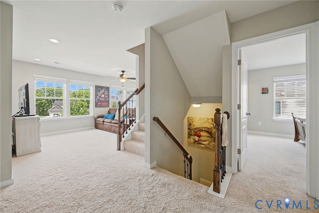 Carpeted upper level with multiple windows, recessed lighting, and a ceiling fan