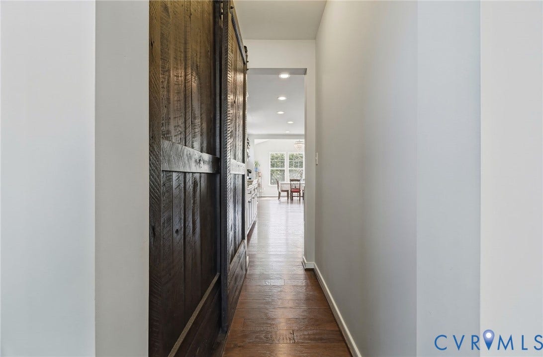 Wood-finish flooring throughout, with a large wood barn door and recessed lighting