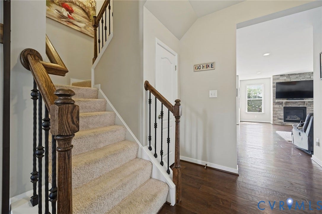 Staircase with wood newel posts and wrought iron balusters
