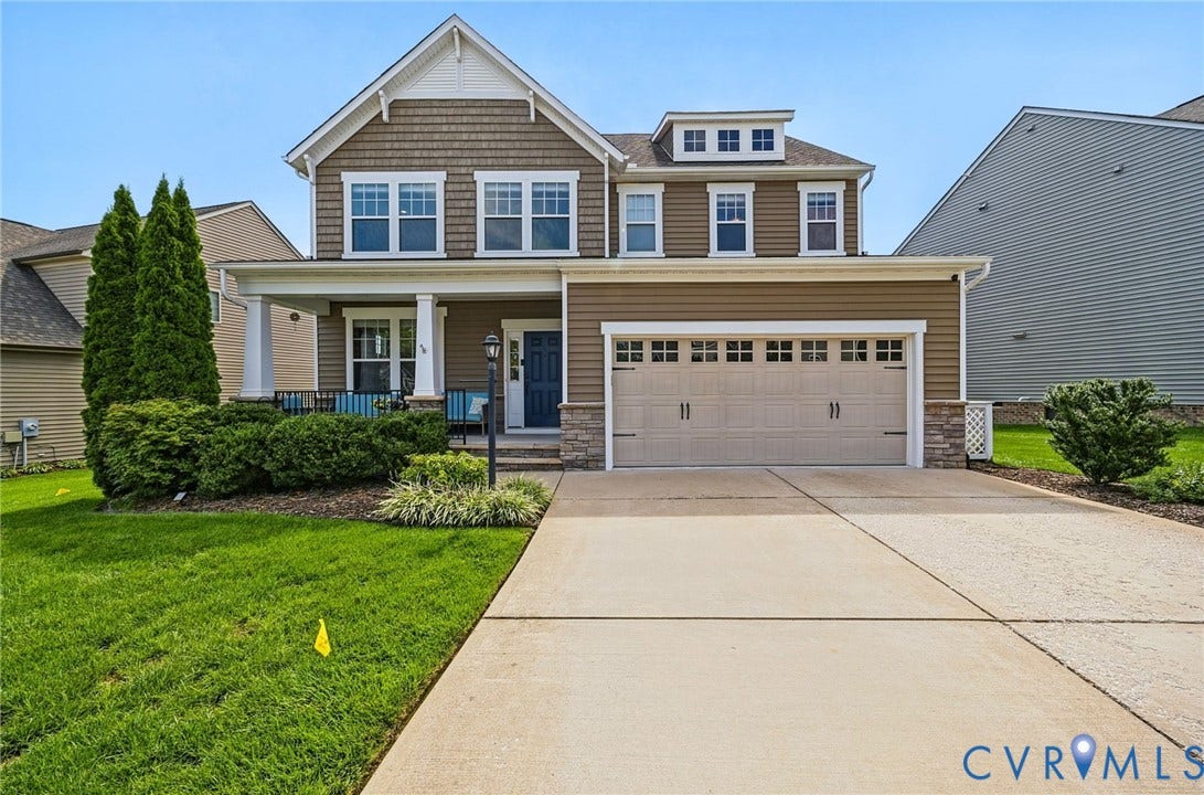 Two-story residence featuring a covered front porch, an attached two-car garage, and a concrete driveway
