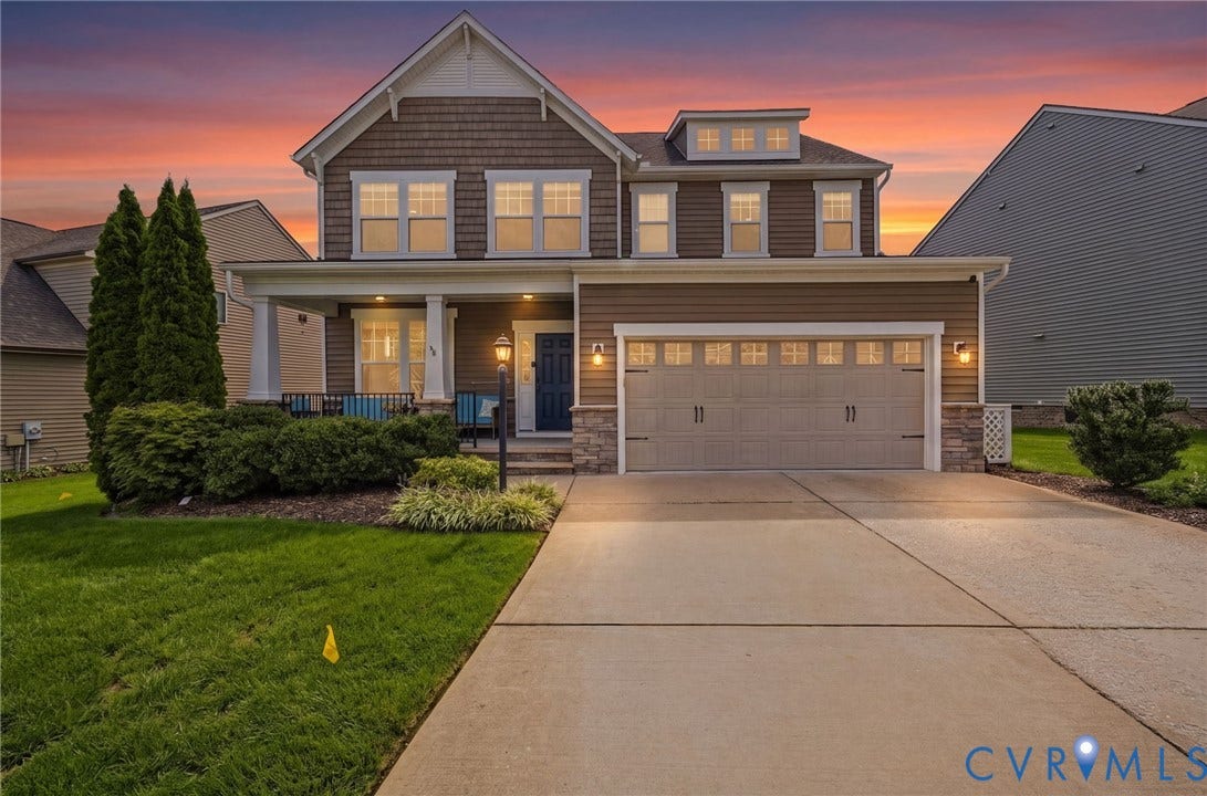 Two-story exterior with a covered porch, attached two-car garage, and concrete driveway