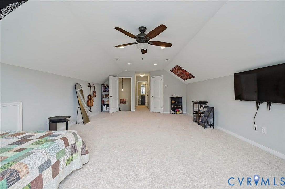 Spacious room featuring vaulted ceilings, light-toned carpeting, recessed lighting, and a ceiling fan