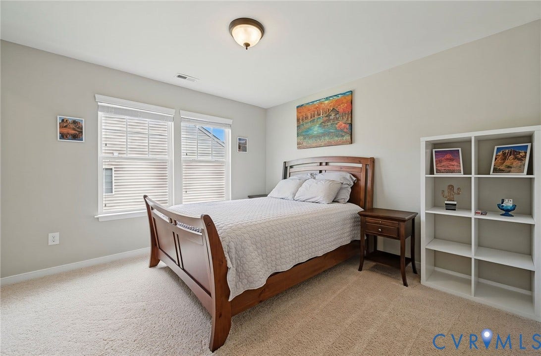 Carpeted flooring, dual windows with blinds, recessed ceiling light, and light-toned walls