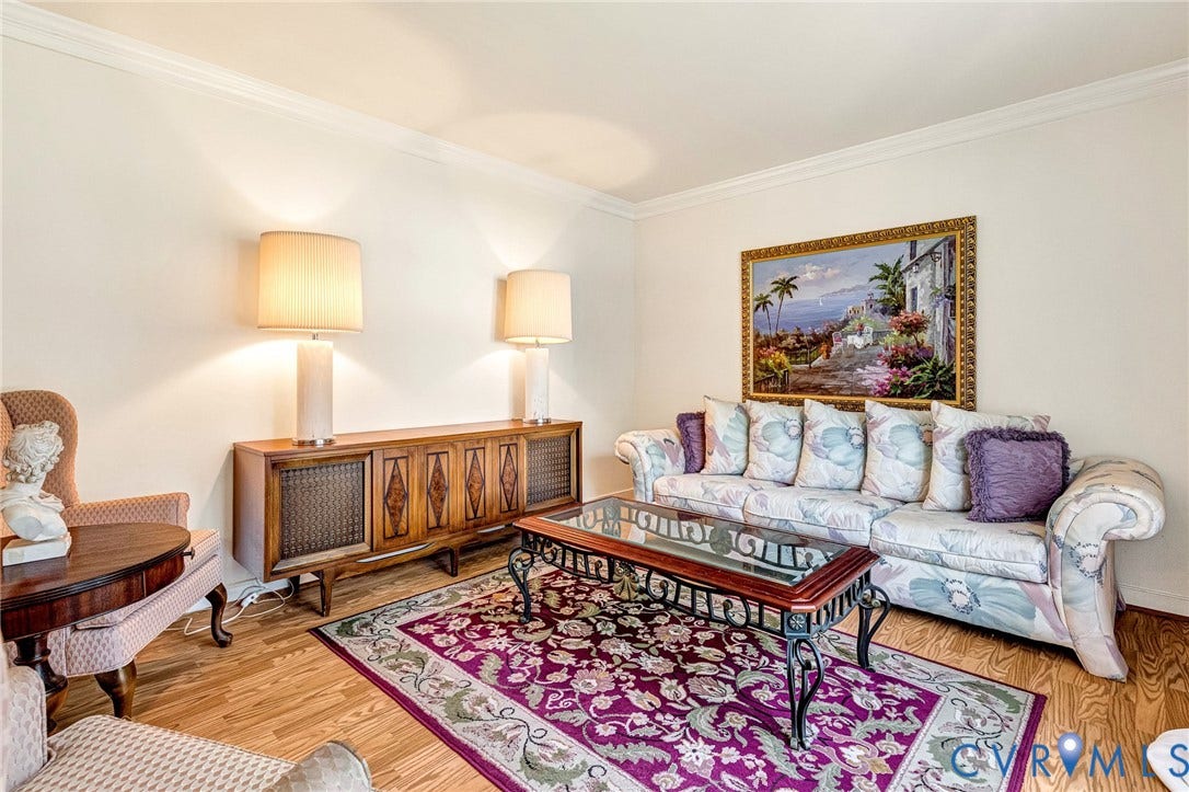 Wood-finish flooring, crown molding, and a built-in wood console with detailed panels