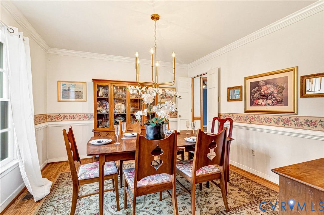 Recessed lighting with a brass chandelier, crown molding, and wood-finish flooring