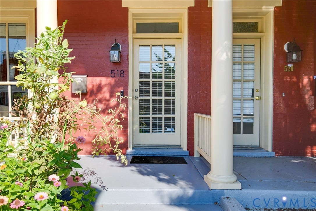 518 N 1st Street, Jackson Ward, Richmond, VA 23219 Red brick exterior with a painted porch, featuring a classic column and a transom window above the entry