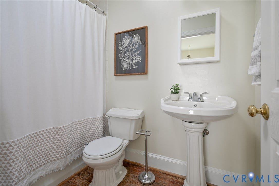 518 N 1st Street, Jackson Ward, Richmond, VA 23219 Pedestal sink with chrome faucet, classic white toilet, and wood-finish flooring