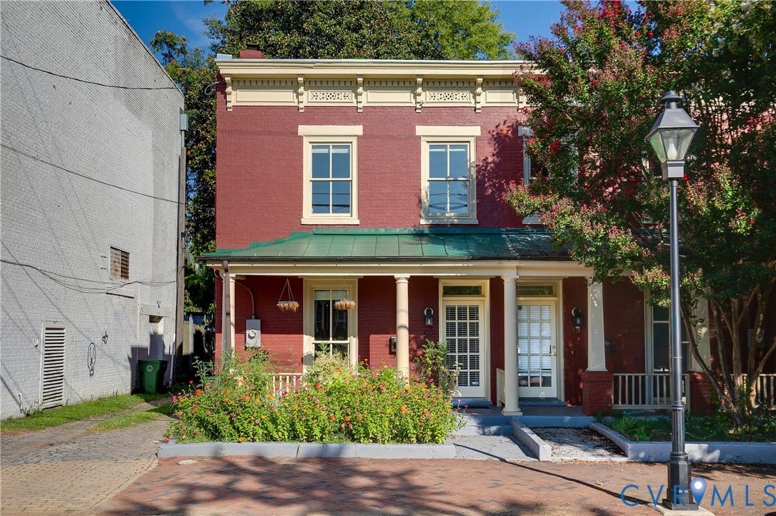 518 N 1st Street, Jackson Ward, Richmond, VA 23219 Brick facade with decorative cornice, featuring a covered porch with round columns and a green metal roof