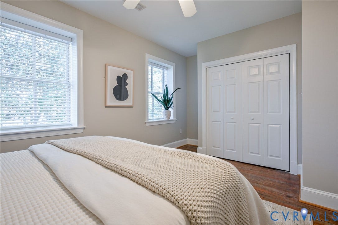 518 N 1st Street, Jackson Ward, Richmond, VA 23219 Wood-finish flooring, white bi-fold closet doors, multiple windows with blinds, and a ceiling fan
