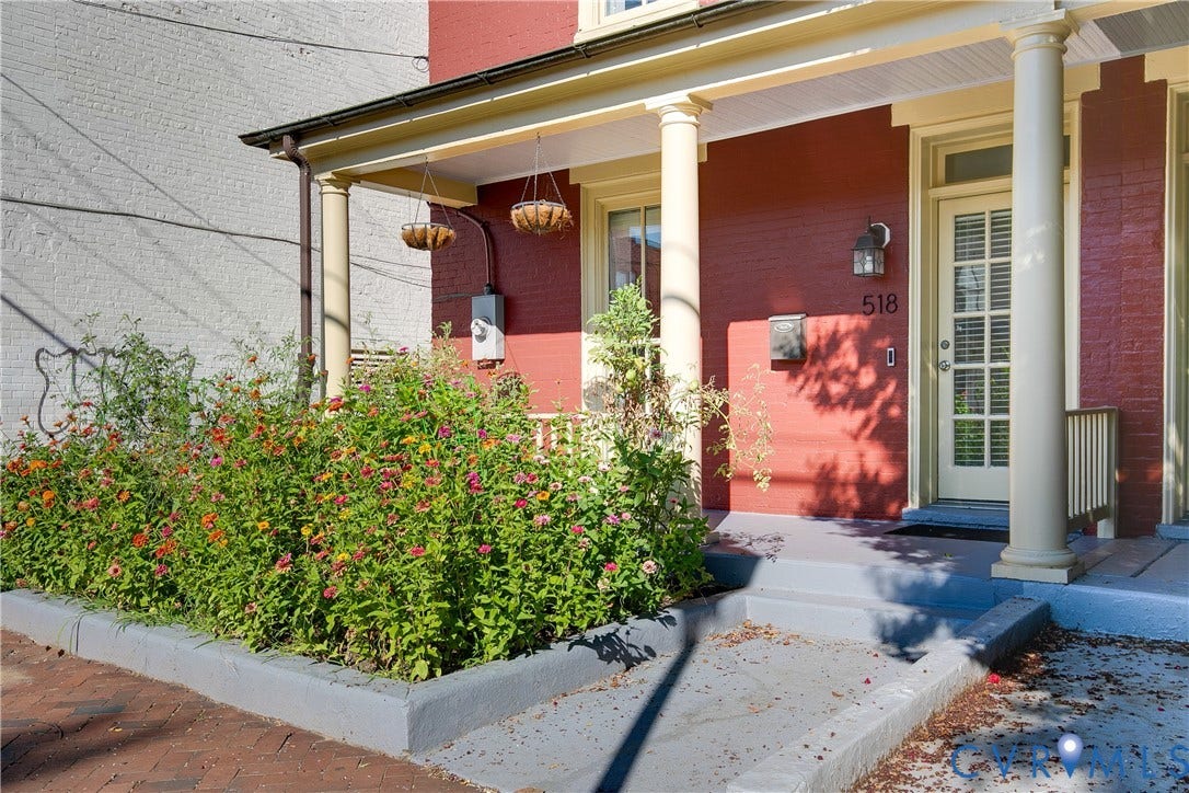 518 N 1st Street, Jackson Ward, Richmond, VA 23219 Red brick exterior with a front porch, white columns, and a light-colored entry door