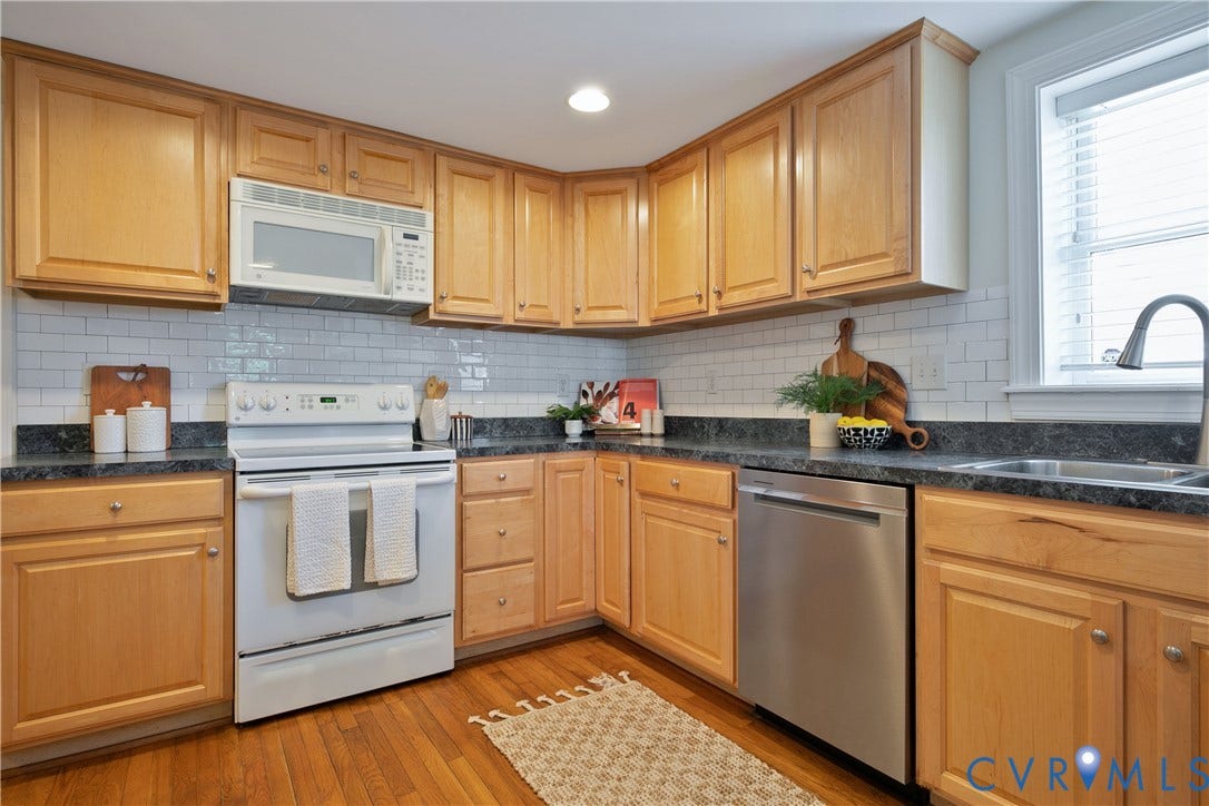 518 N 1st Street, Jackson Ward, Richmond, VA 23219 Hardwood-finish flooring, light wood cabinetry, stone-finish countertops, white subway tile backsplash, and a stainless steel dishwasher
