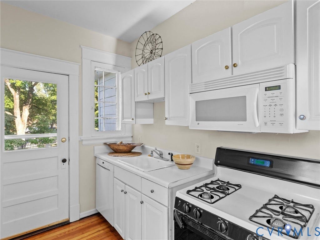 Kitchen featuring white cabinetry, white countertop, stainless steel sink, over-the-range microwave, and a gas range