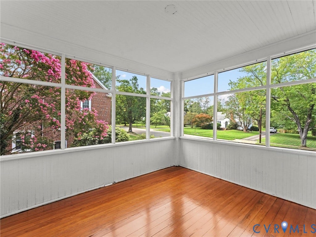 Bright sunroom with expansive multi-pane windows offering abundant natural light and outdoor vistas