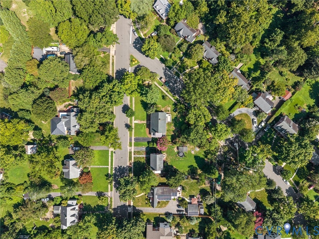 Aerial view showcasing a tree-lined residential street with multiple homes situated on generous, landscaped lots