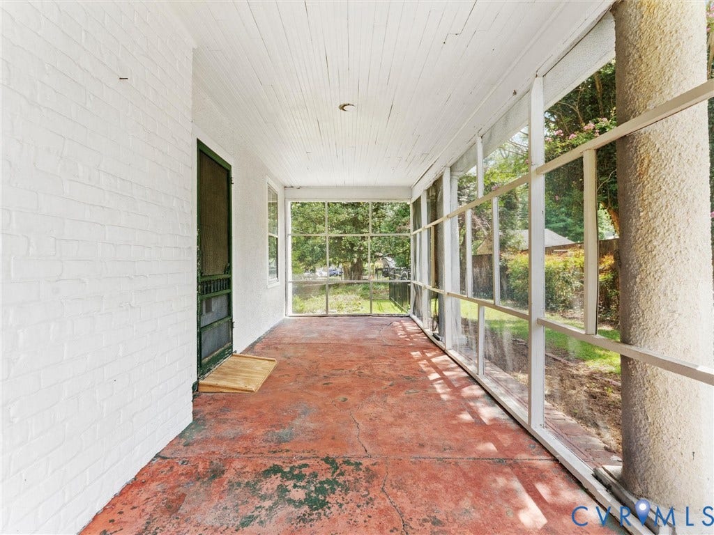 Screened porch with expansive windows offering natural light and outdoor visibility, terracotta tile flooring, and white shiplap ceiling