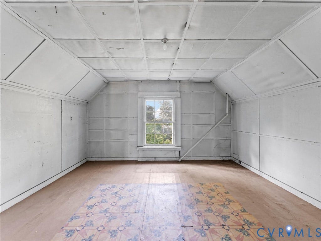 Spacious interior room with drywall-finished walls, suspended ceiling with integrated electrical infrastructure, and wood-finish flooring
