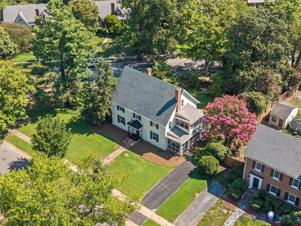 Charming Colonial-style residence showcasing a slate-gray shingle roof, white exterior trim, and a front-facing covered porch