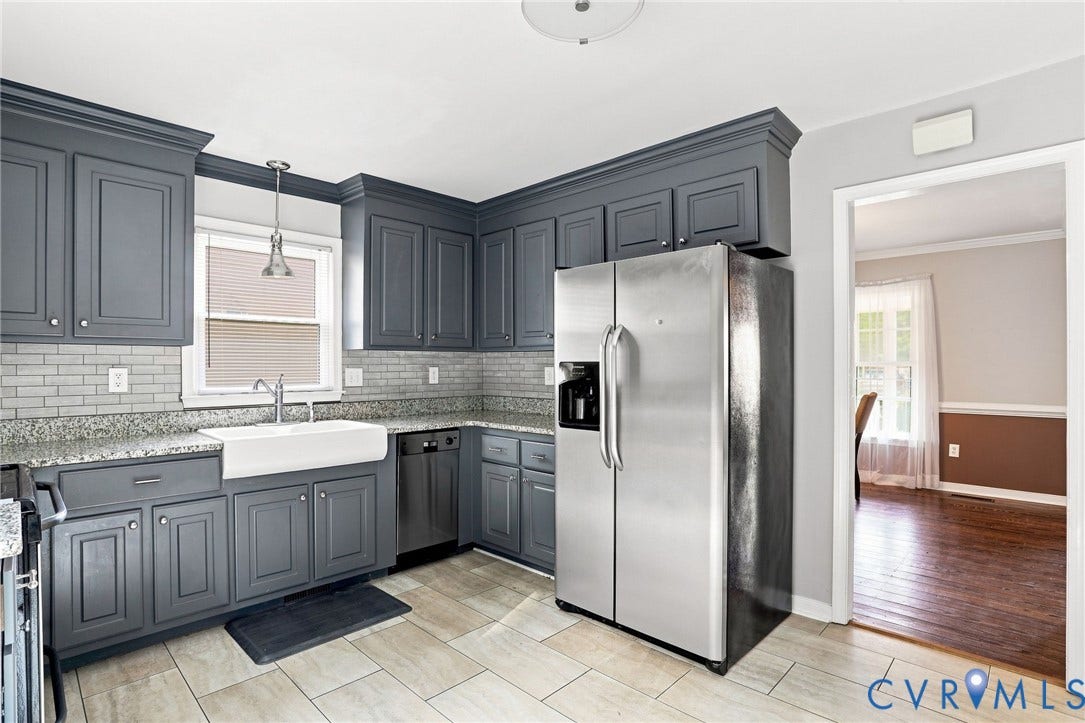 Kitchen featuring grey cabinetry, stainless steel appliances, granite countertops, and a farmhouse sink