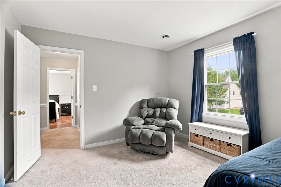 Soft carpeted flooring, light gray wall paint, and a bright window with a white frame
