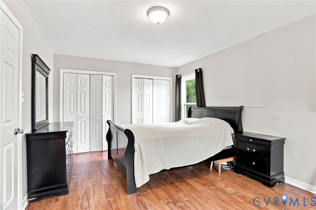 Wood-finish flooring, white bi-fold closet doors, and a ceiling-mounted light fixture