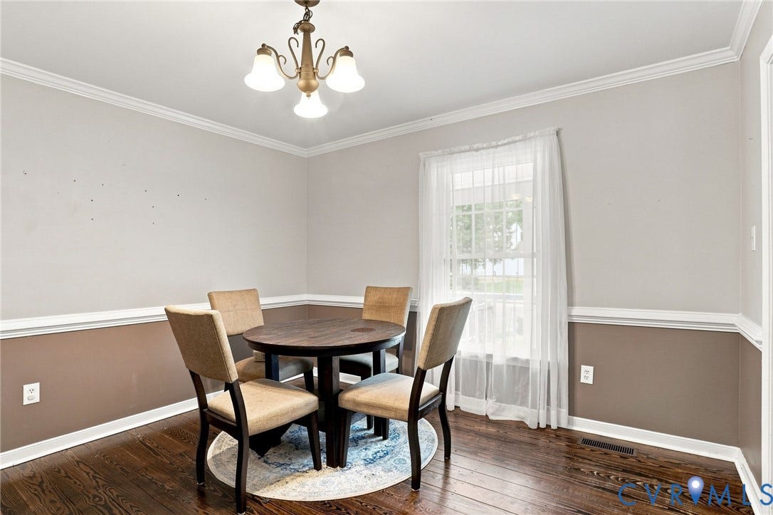 Wood-finish flooring, crown molding, and chair rail detailing