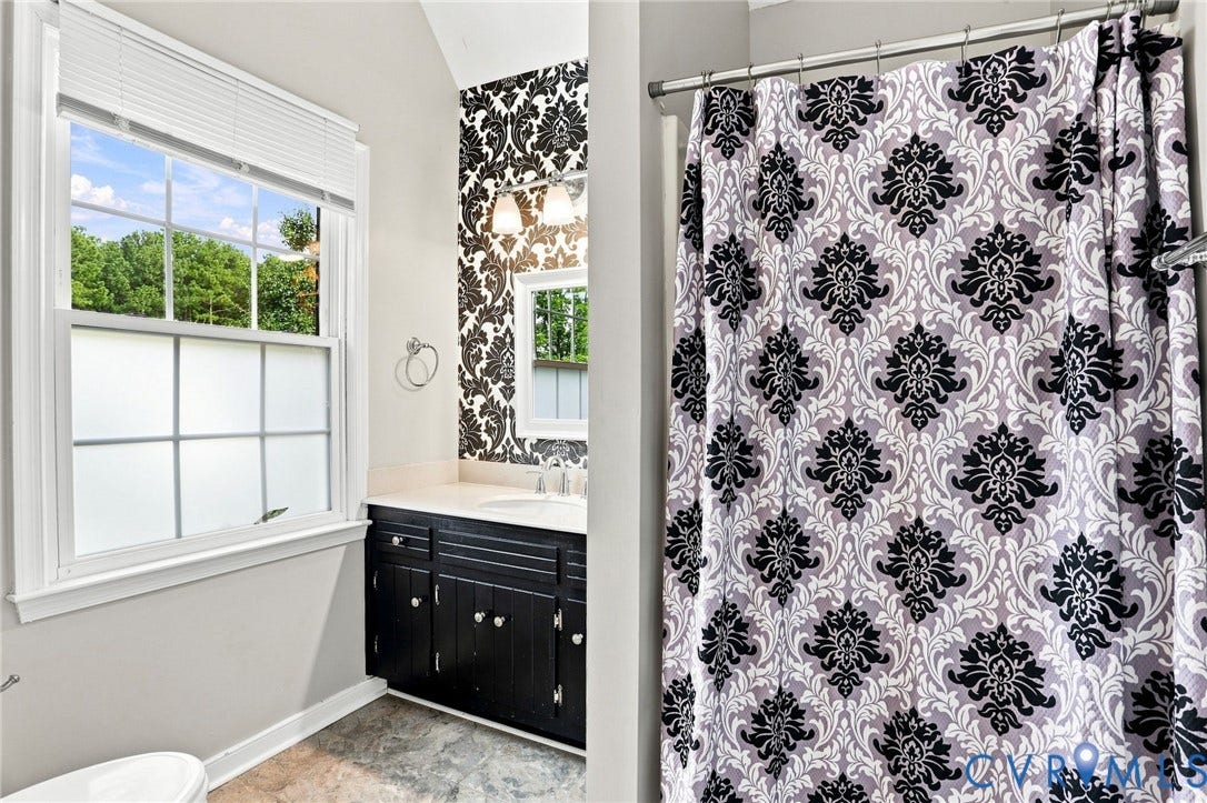 Single-sink vanity with a dark wood-finish cabinet and light-colored countertop