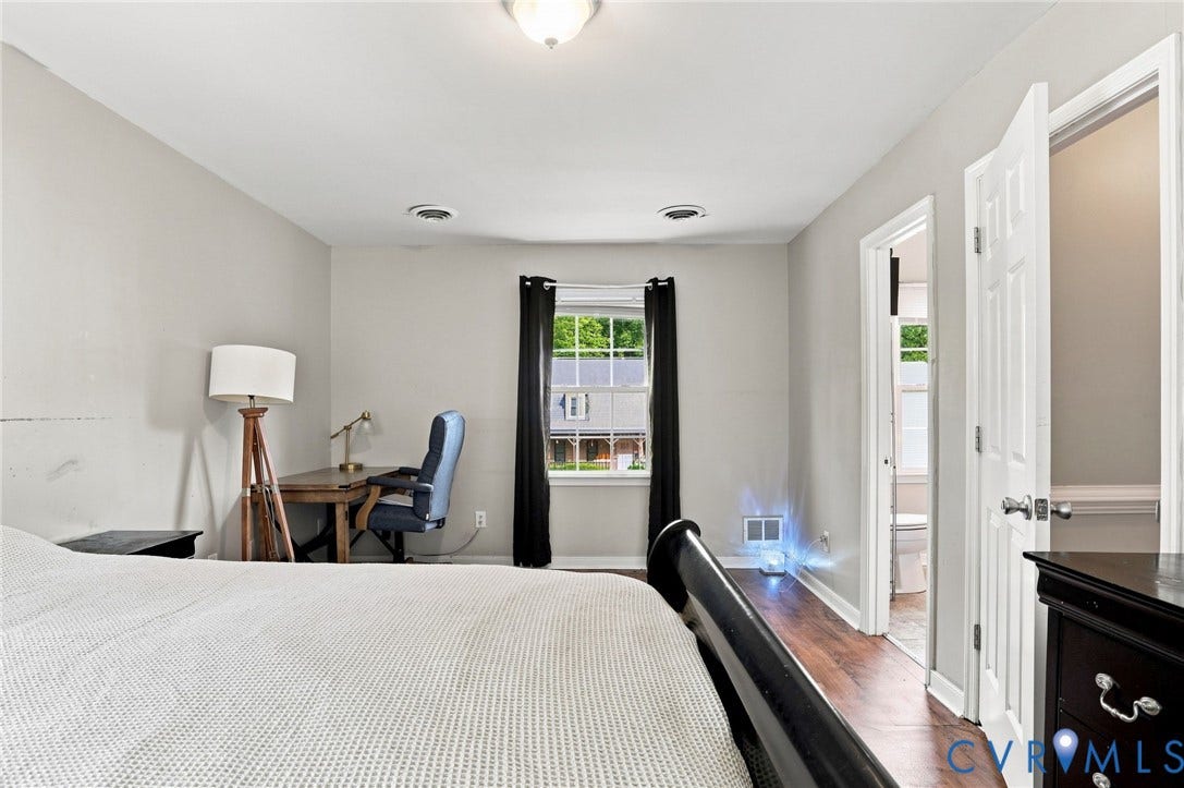 Neutral wall paint, recessed ceiling lighting, wood-finish flooring, white paneled doors, and a double-pane window