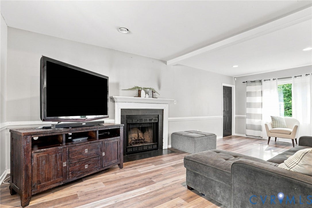 Fireplace with a white mantel, recessed lighting, wood-finish flooring, white walls, and a white ceiling beam
