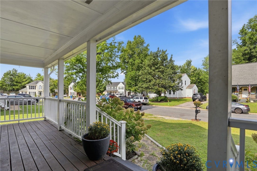 Covered front porch with wood-finish decking and white railings