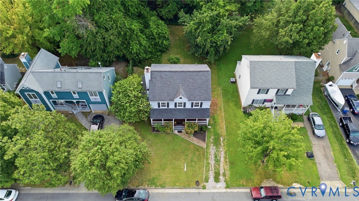 Two-story residence featuring a covered front porch, dormer window, and dark-paneled shutters
