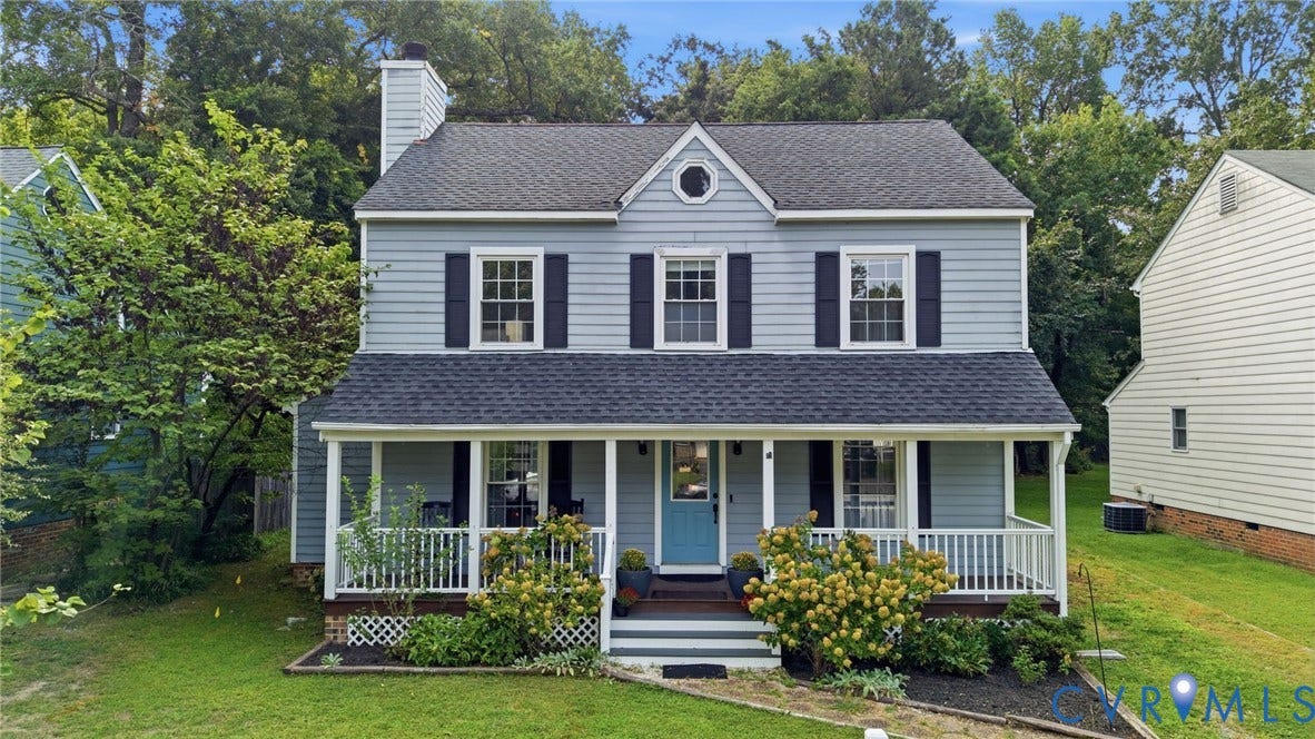 Two-story siding exterior with a covered front porch, white railings, and a light blue front door