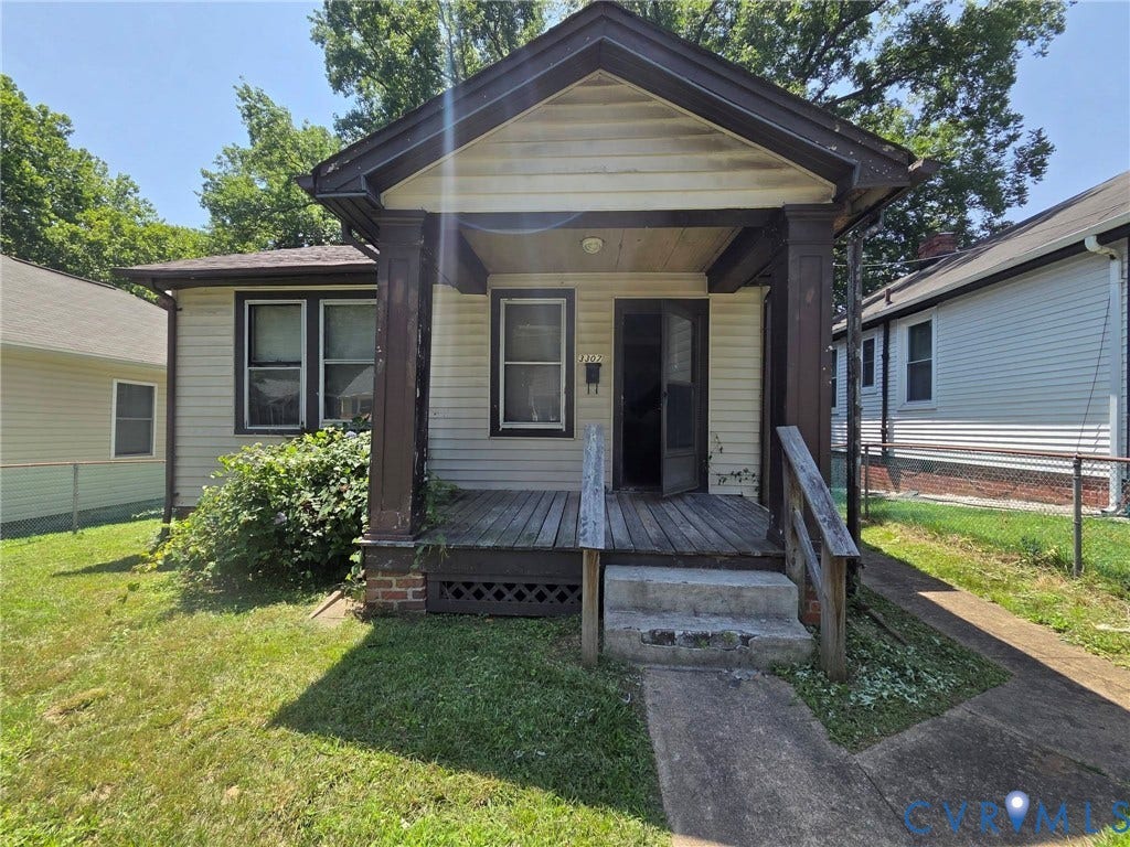 Front porch with wood decking, wood railing, and concrete steps