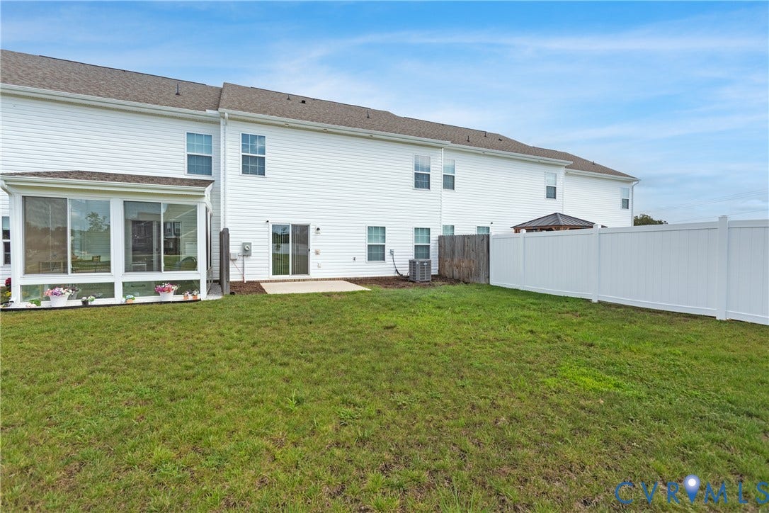 11419 Dunmore Mill Court, Chester, VA 23831 Expansive backyard with a manicured lawn, a full-height privacy fence, and a patio area