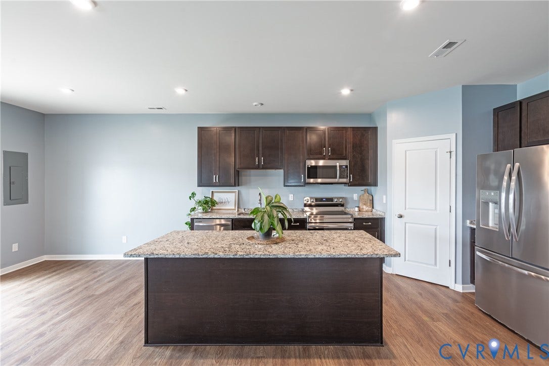 11419 Dunmore Mill Court, Chester, VA 23831 Chef's kitchen featuring dark wood cabinetry, stainless steel appliances, and a large island with speckled stone countertops