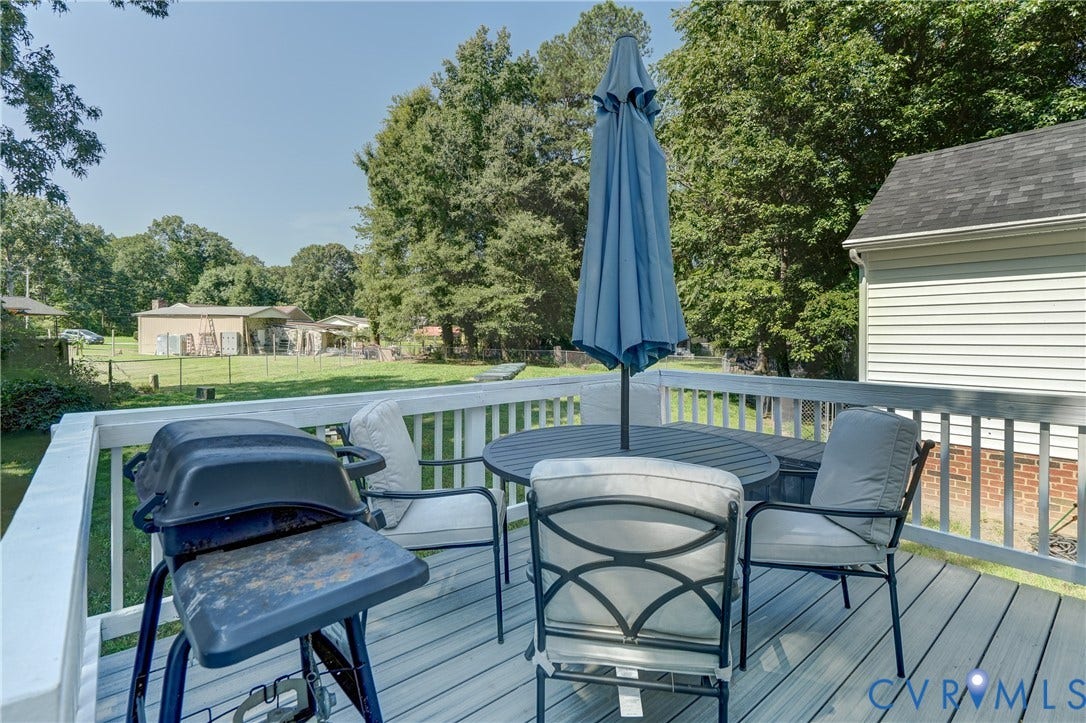 4229 Greenbriar Drive, Chester, VA 23831 Deck with white railing and composite decking, bordered by a green lawn and mature trees