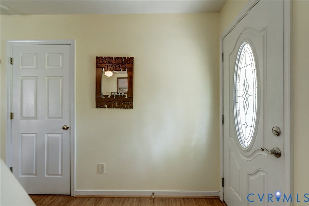 4229 Greenbriar Drive, Chester, VA 23831 Bright entryway with warm wood-finish flooring, dual panel doors with decorative hardware, and an elegant arched glass-panel entry door with sidelights