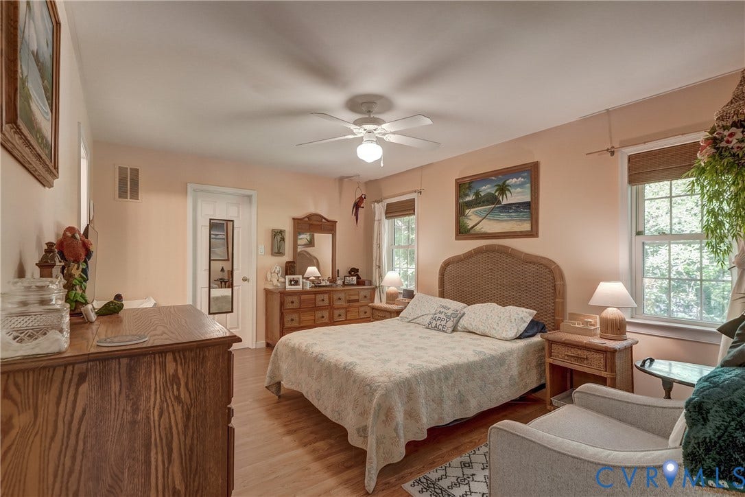 4229 Greenbriar Drive, Chester, VA 23831 Wood-finish flooring, ceiling fan, and multiple windows with woven Roman shades