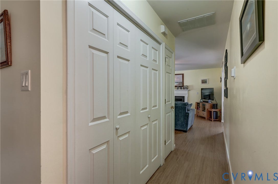 4229 Greenbriar Drive, Chester, VA 23831 Hallway with wood-finish flooring and paneled bi-fold doors