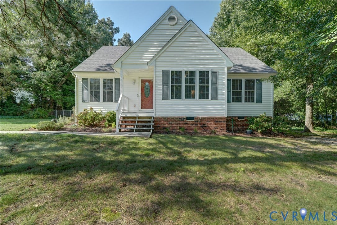 4229 Greenbriar Drive, Chester, VA 23831 White siding exterior with a red front door, multiple windows, and a brick foundation